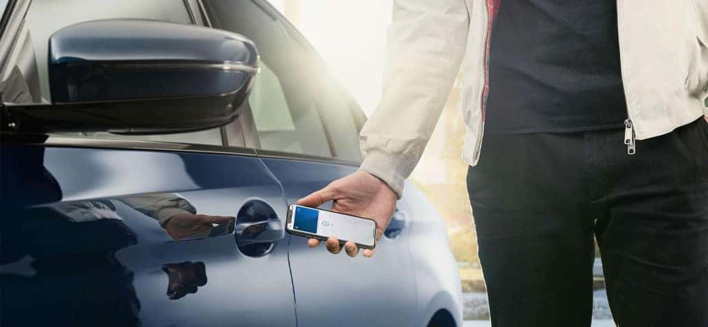 A driver uses his smartphone equipped with BMW Digital Key Plus to unlock his BMW 3 Series.
