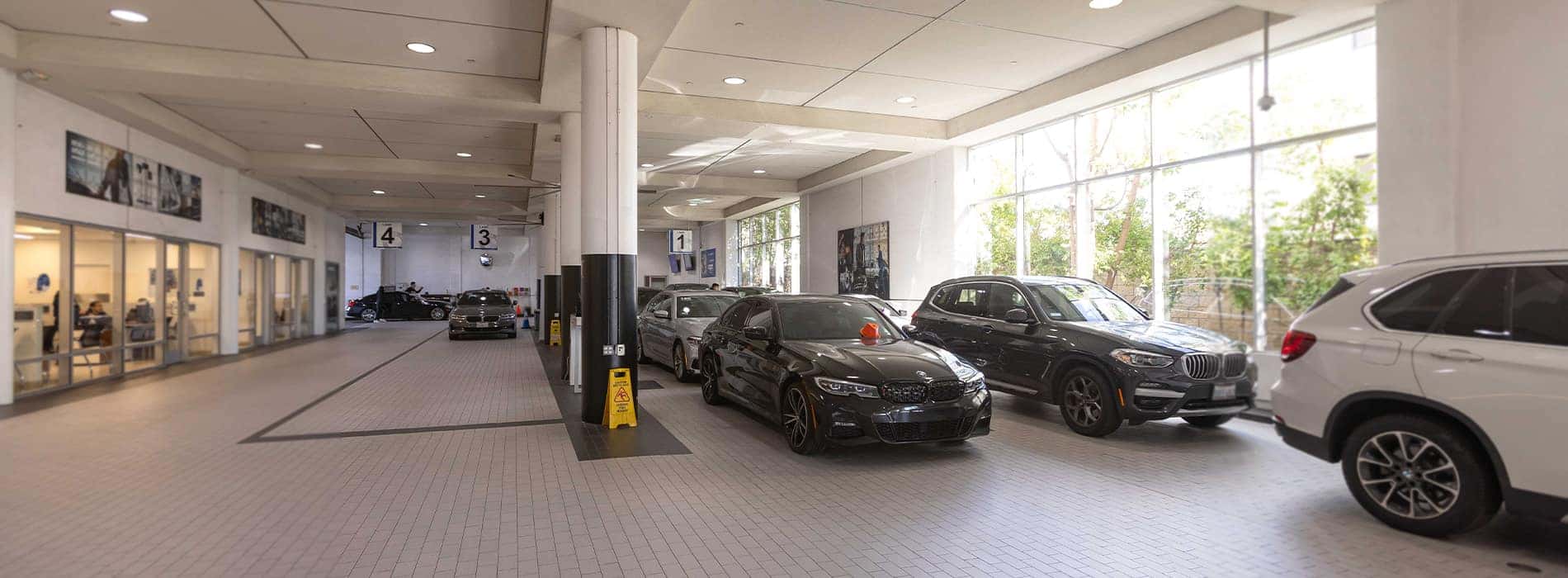 BMW 3 Series, BMW X3, and BMW X5 await service on the Pacific BMW service drive.