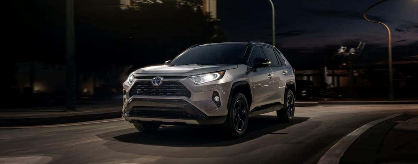 A silver 2020 Toyota RAV4 is shown leaving a Toyota Dealer in Sinking Spring at night.