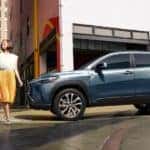 A blue 2022 Toyota Corolla Cross XLE is shown parked on a city street.