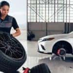 A technician is shown changing the wheel on a white 2022 Toyota Camry TRD.