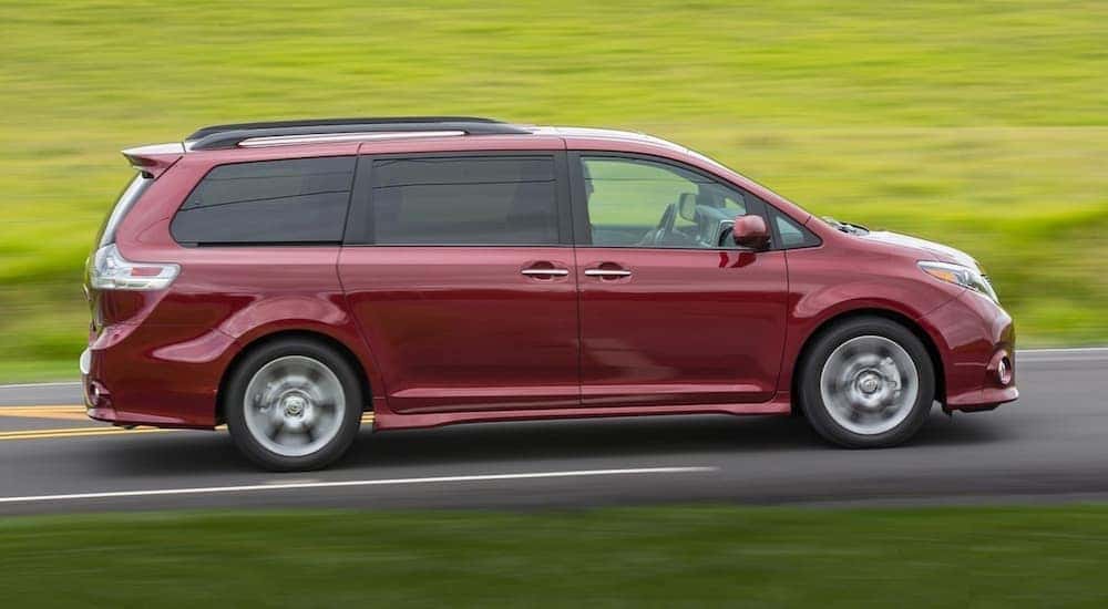 A red 2017 Toyota Sienna is shown form the side driving on an open road after leaving a used Toyota dealer near you.