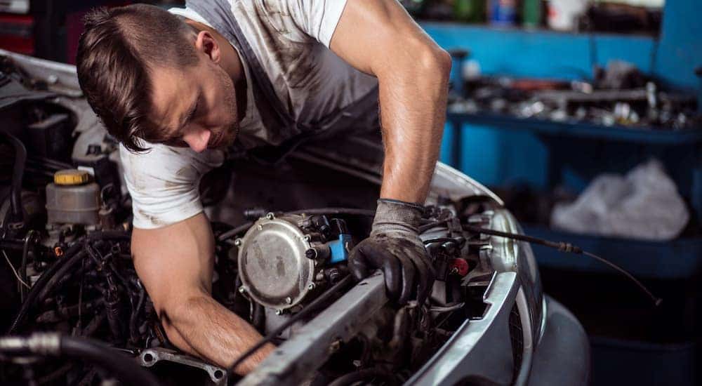 A mechanic is shown servicing a car at a used car dealer near you.