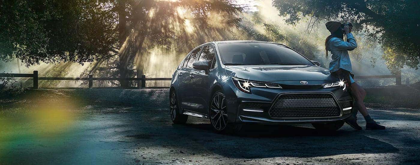 A person is shown taking photos next to a grey 2020 Toyota Corolla XSE.
