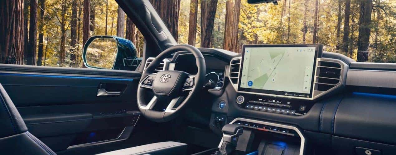 A close up of the steering wheel and infotainment screen in a 2023 Toyota Sequoia are shown.