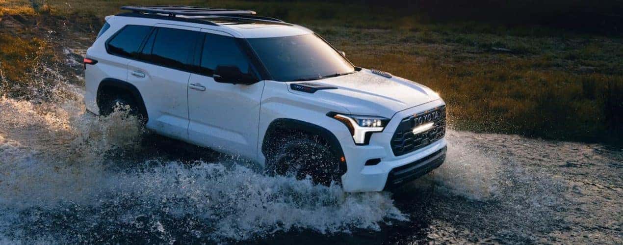 A white 2023 Toyota Sequoia TRD Pro is shown driving through a river.