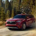 A red 2020 Toyota Highlander is shown from the front on a dirt road.