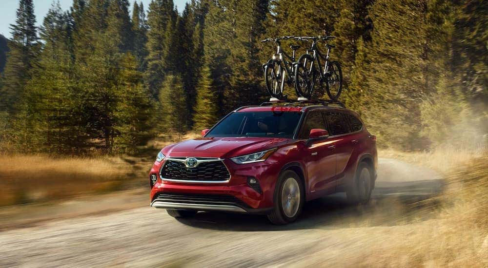 A red 2020 Toyota Highlander is shown from the front on a dirt road.