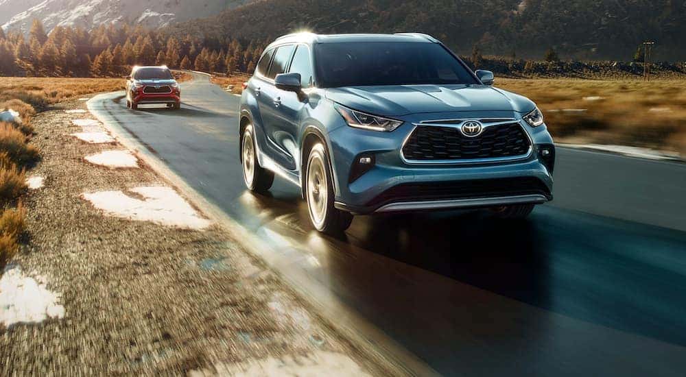 A blue 2022 Toyota Highlander is shown from the front while driving.