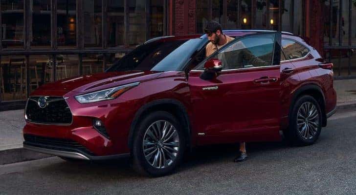 A person is shown entering a maroon 2020 Toyota Highlander Hybrid.