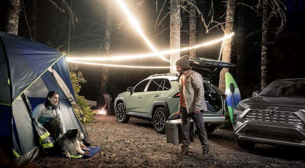 A grey 2022 Toyota RAV4 Limited is shown at a campsite at night.