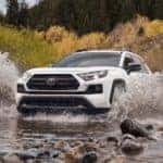 A white 2022 Toyota RAV4 TRD Pro is shown driving through a river.