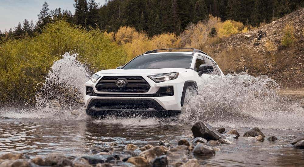 A white 2022 Toyota RAV4 TRD Pro is shown driving through a river.