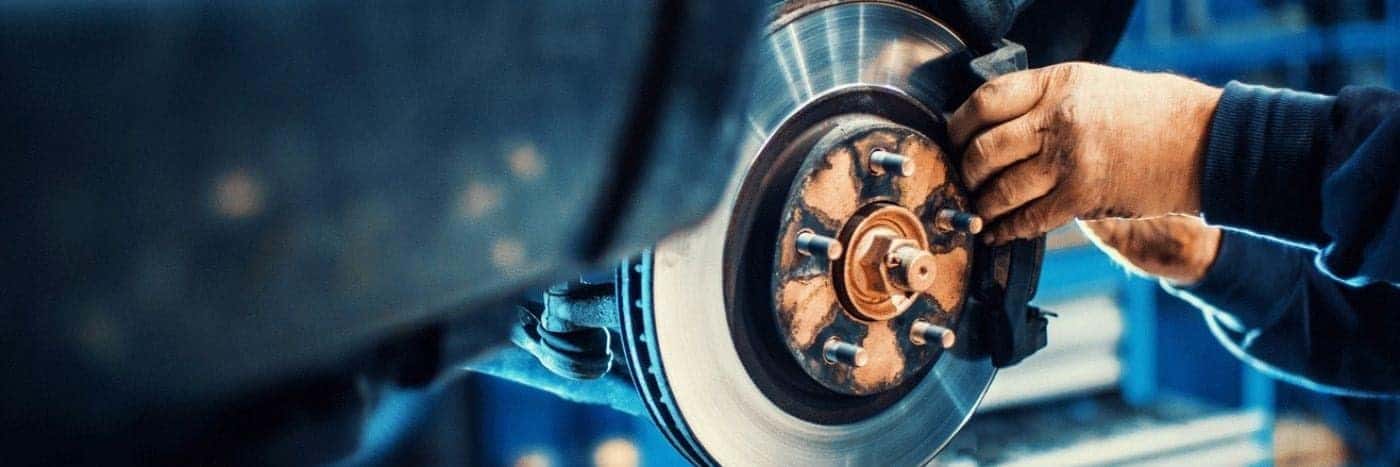Close up view of a service tech working on a brake rotor