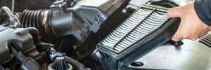 Close up view of a service tech holding an engine air filter