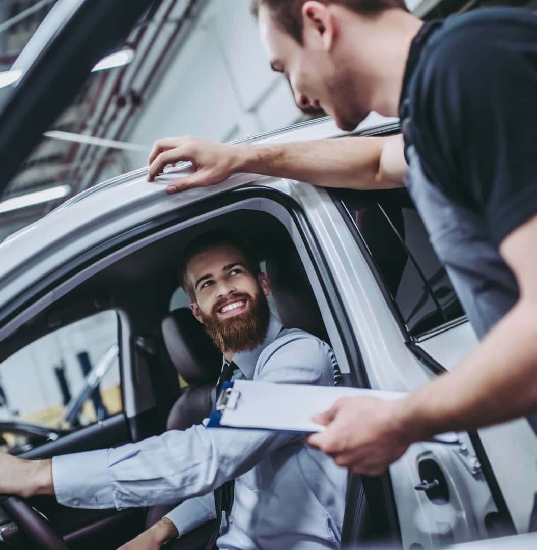 Customer speaking with an automotive professional while seated inside a vehicle.