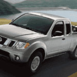 2019 Nissan Frontier towing a trailer with car on rural highway