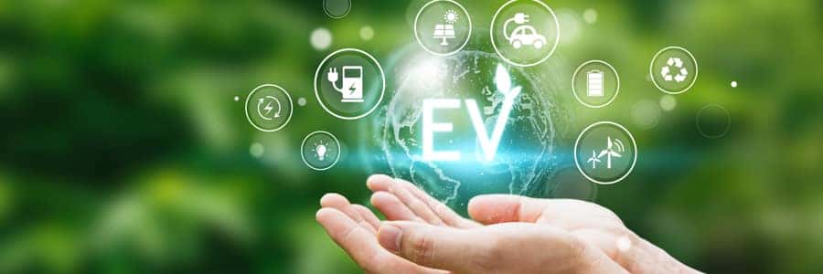 Hand of human holding global with EV icons.