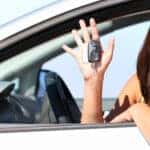 teenager smiling outside the window of her vw car
