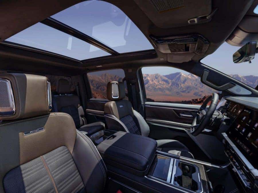 2027 GMC Sierra 1500 AT4X interior with Timber Mahogany colorway and flat-bottom sport steering wheel